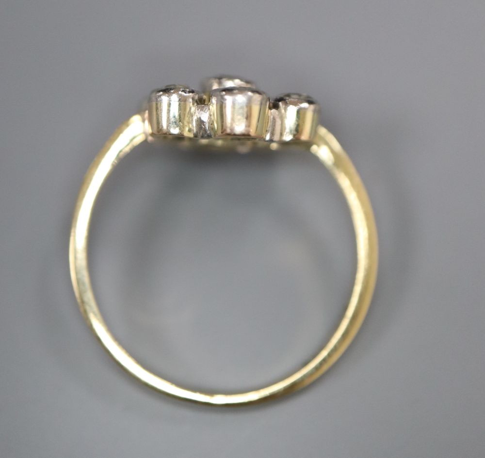 A 750 yellow metal and seven stone diamond cluster flower head ring, size L, gross 3.3 grams.